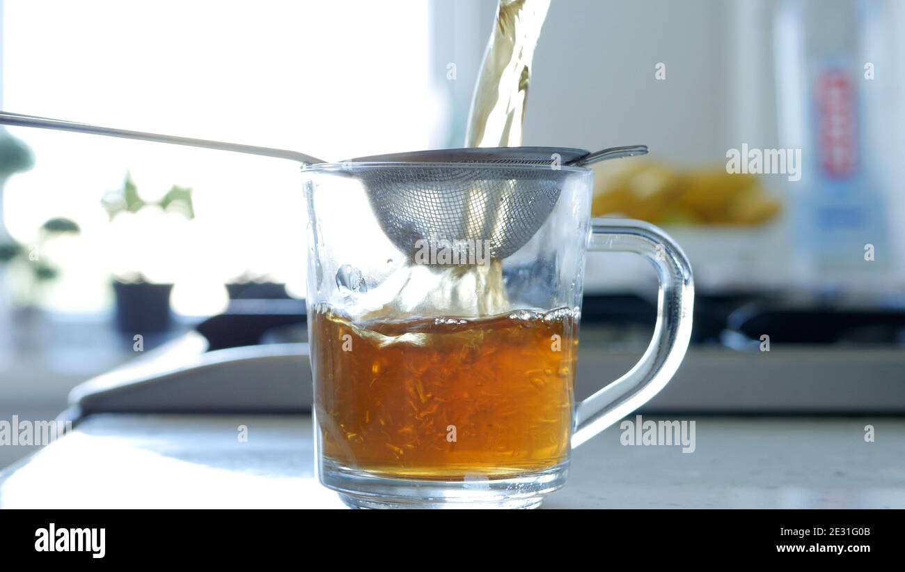 Bild mit der Herstellung eines heißen und aromatischen Tee mit einem Sieb und natürliche Tee Leafs Stockfoto