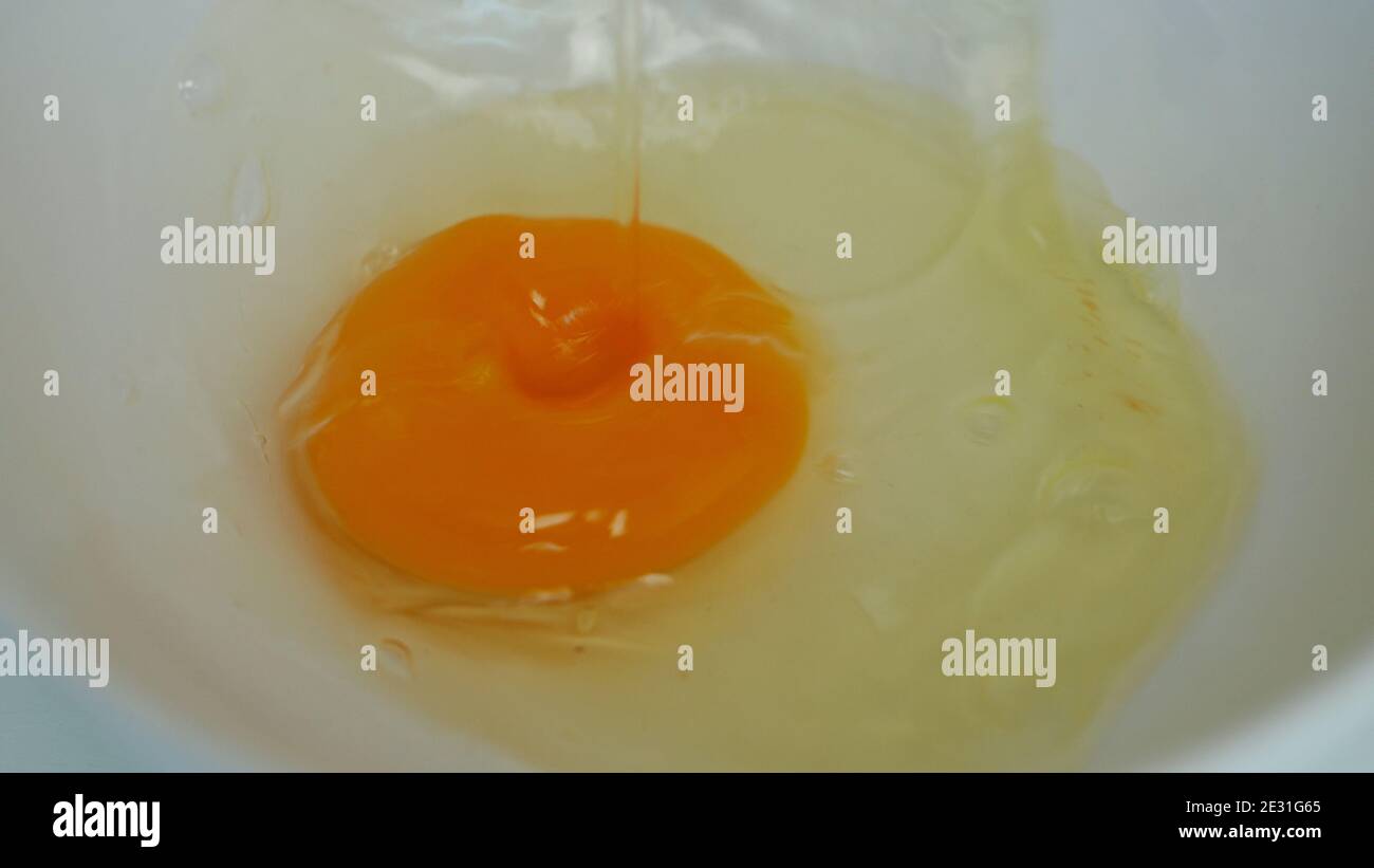 Nahaufnahme Bild mit einem frischen Ei Weiß und Eigelb Vorbereitet zum Kochen in der Küche zum Frühstück Stockfoto