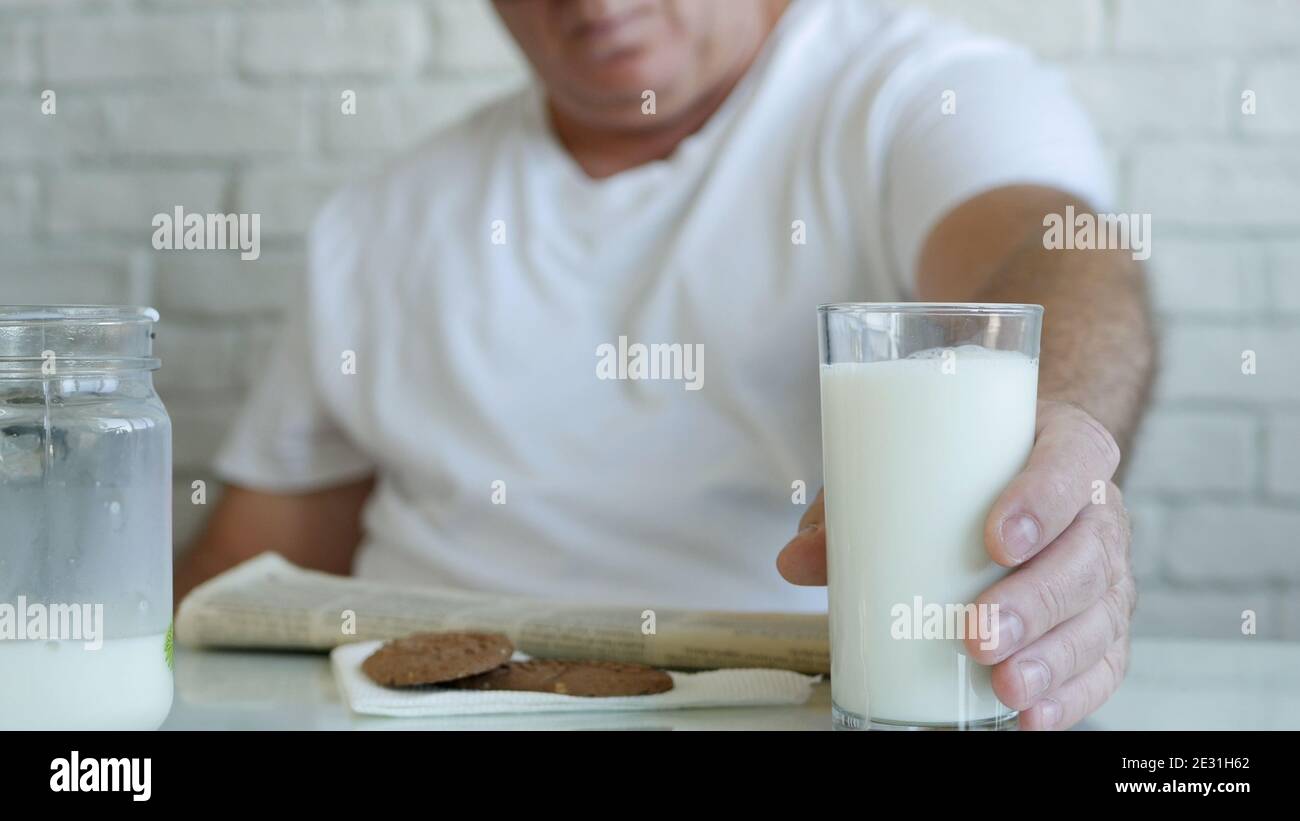 Bild mit einem Mann, der beim Frühstück frische Milch trinkt Einen Morgen Stockfoto