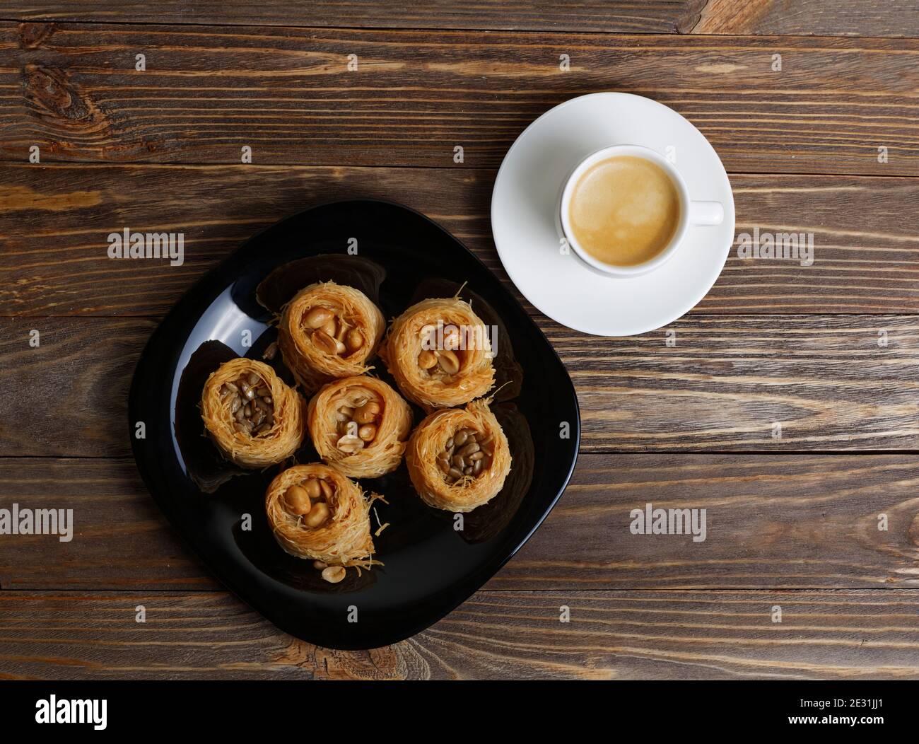 Östliche Süßigkeiten Baklava und Tasse Kaffee Espresso auf Holztisch. Draufsicht. Stockfoto