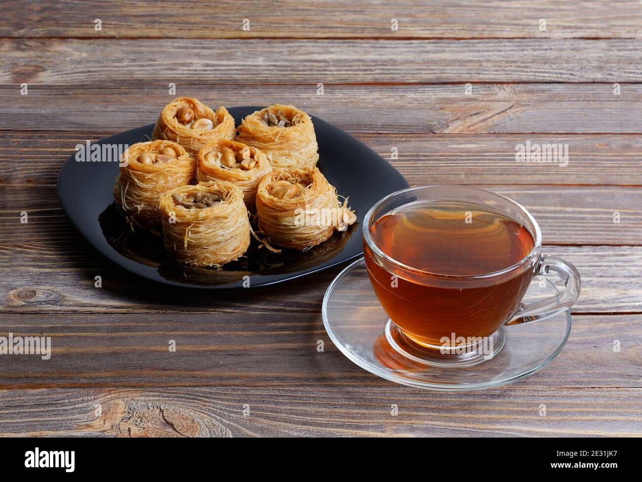 Tasse Tee und östliche Süßigkeiten - Baklava auf Holz Tabelle Stockfoto