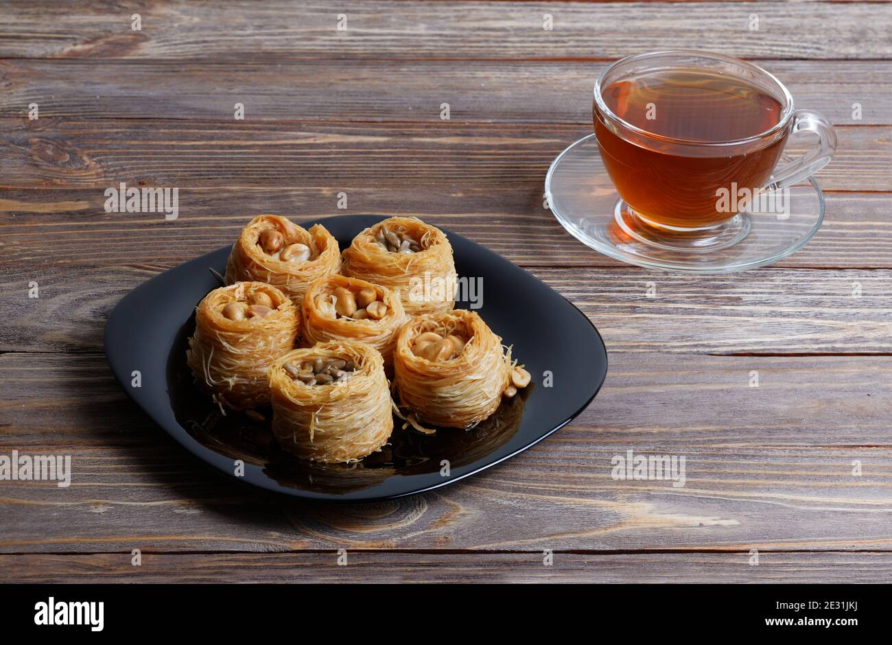 Tasse Tee und östliche Süßigkeiten - Baklava auf Holz Tabelle Stockfoto