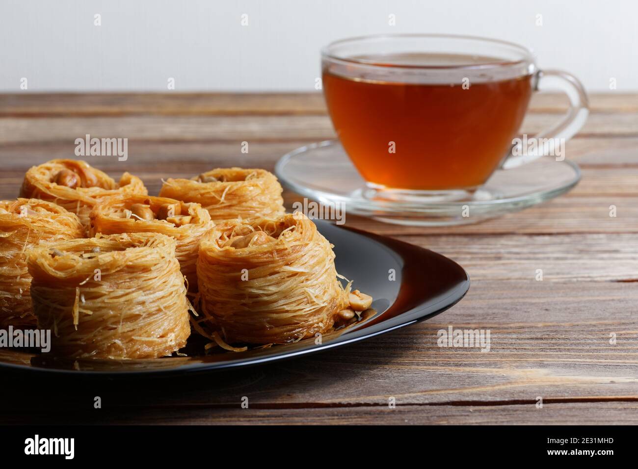 Östliche Süßigkeiten auf Holztisch und eine Tasse Tee auf dem Hintergrund. Geringer Fokus. Stockfoto