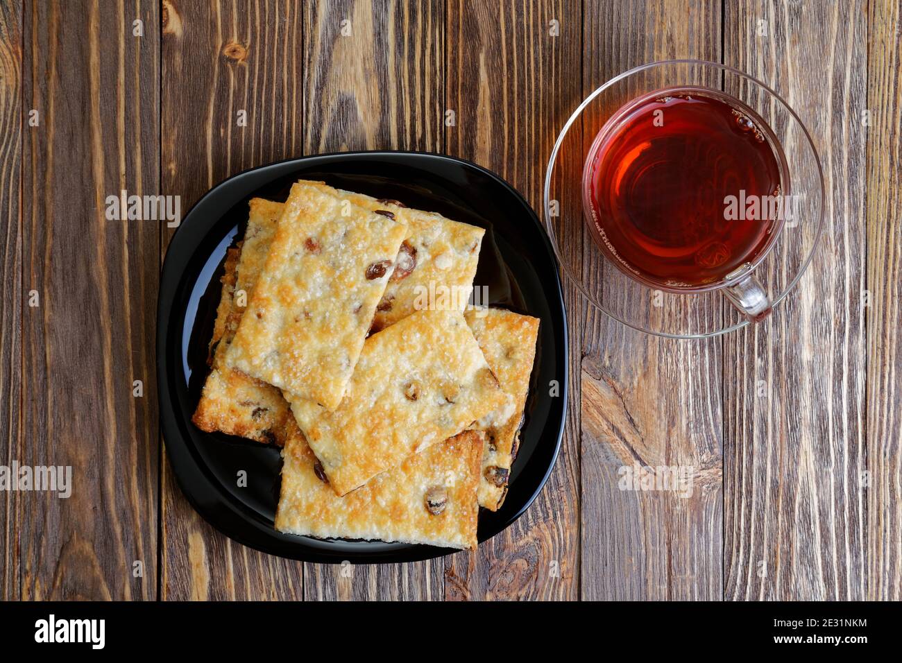 Kekse mit Rosinen und eine Tasse porzellan-Tee auf dem dunklen Holztisch. Draufsicht. Stockfoto