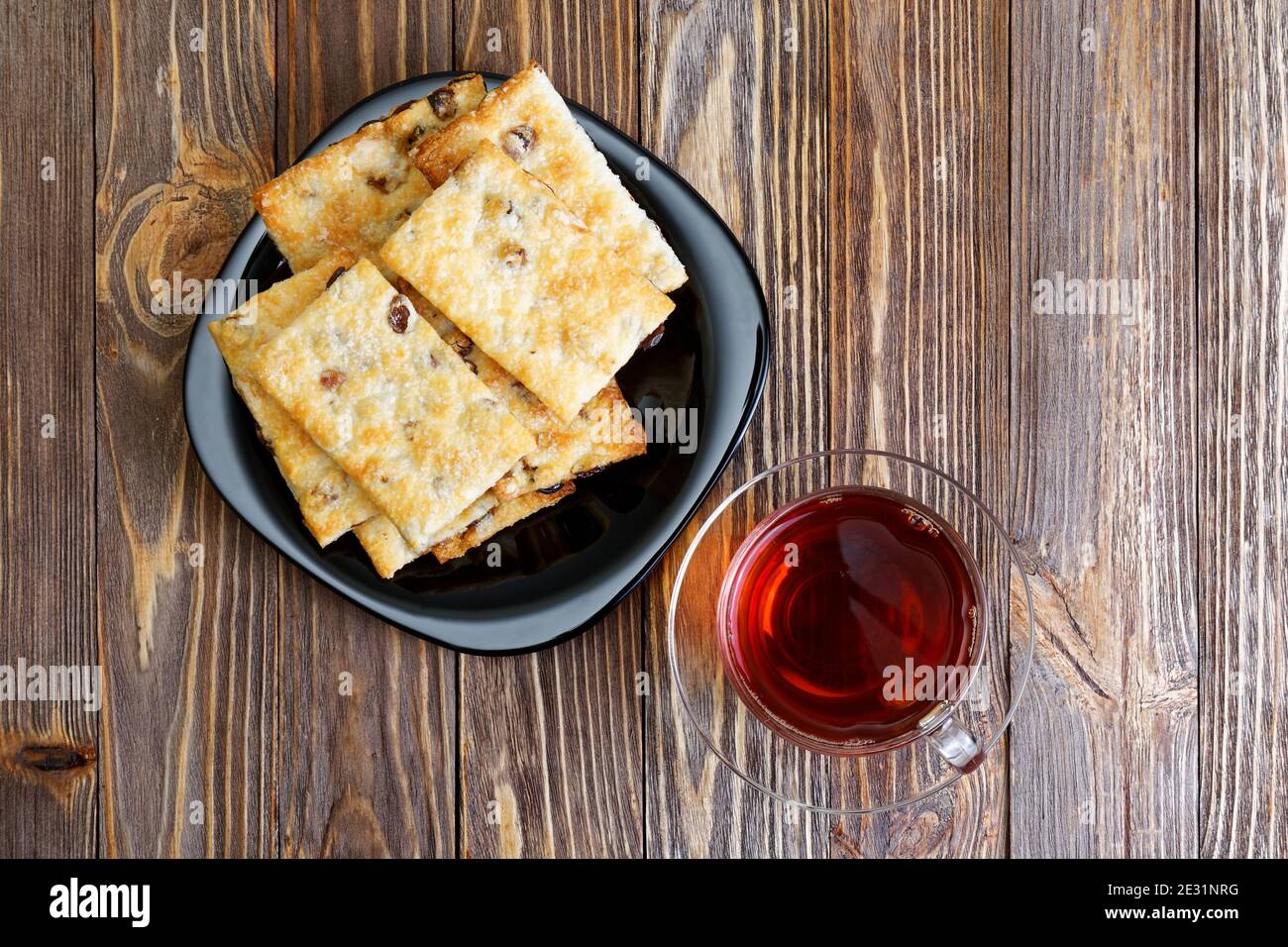 Kekse mit Rosinen und eine Tasse porzellan-Tee auf dem dunklen Holztisch. Draufsicht. Stockfoto