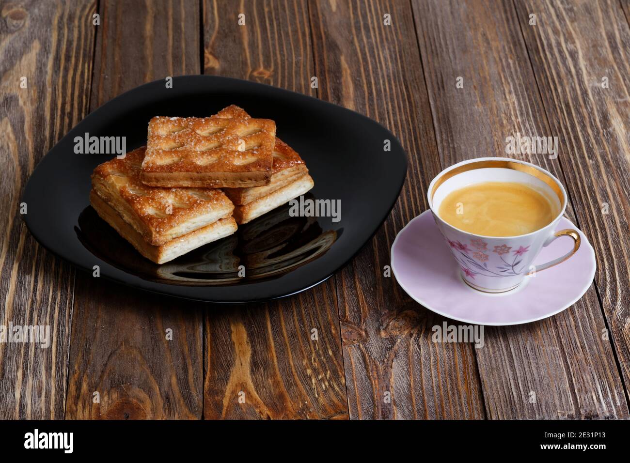 Kekse und eine Tasse Kaffee auf dem dunklen Holztisch. Winkelansicht. Stockfoto