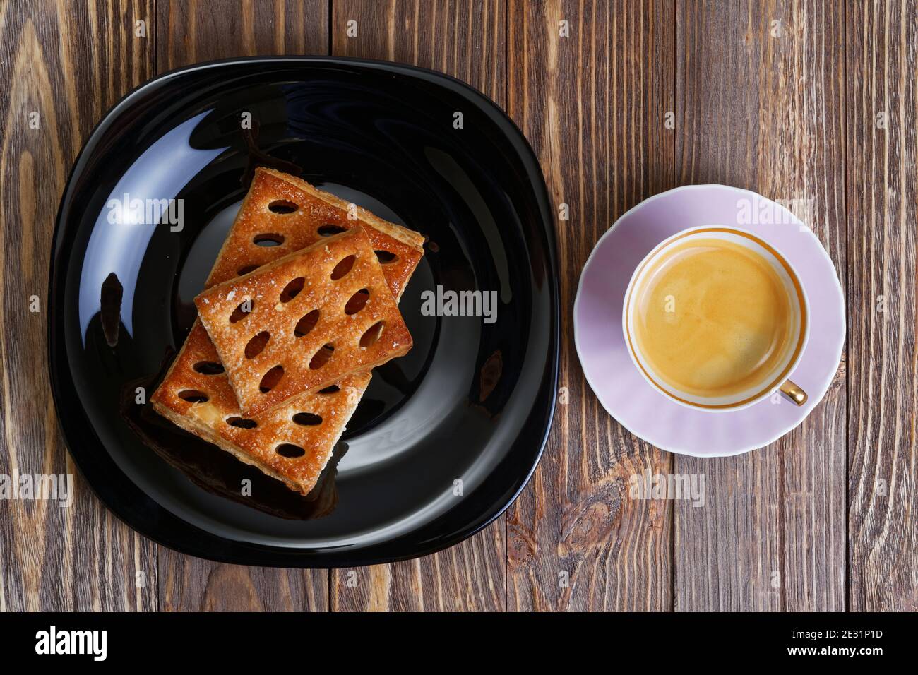 Kekse und eine Tasse Espresso auf dem dunklen Holztisch. Draufsicht Stockfoto