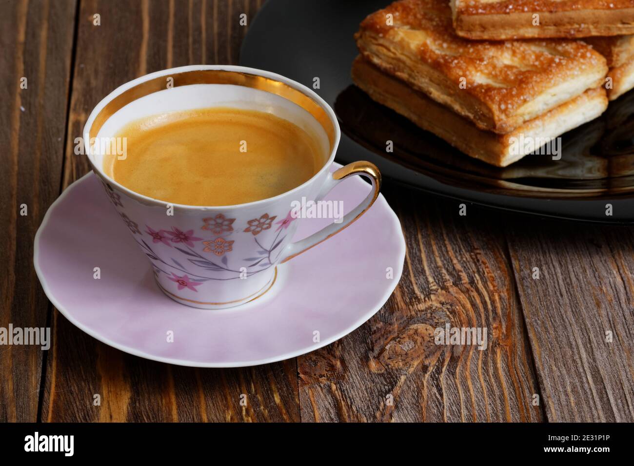 Kekse und eine Tasse Kaffee auf dem dunklen Holztisch. Geringer Fokus. Stockfoto