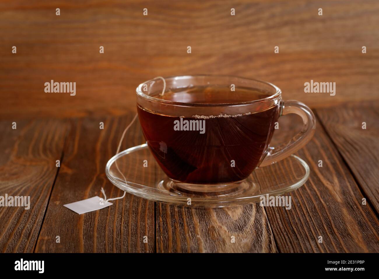 Nahaufnahme Tasse Tee auf Holztisch. Teebeutel mit weißem Etikett. Stockfoto