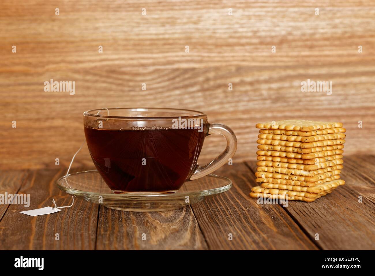 Tasse Tee und Kekse auf einem Holztisch. Teebeutel mit weißem Etikett. Stockfoto