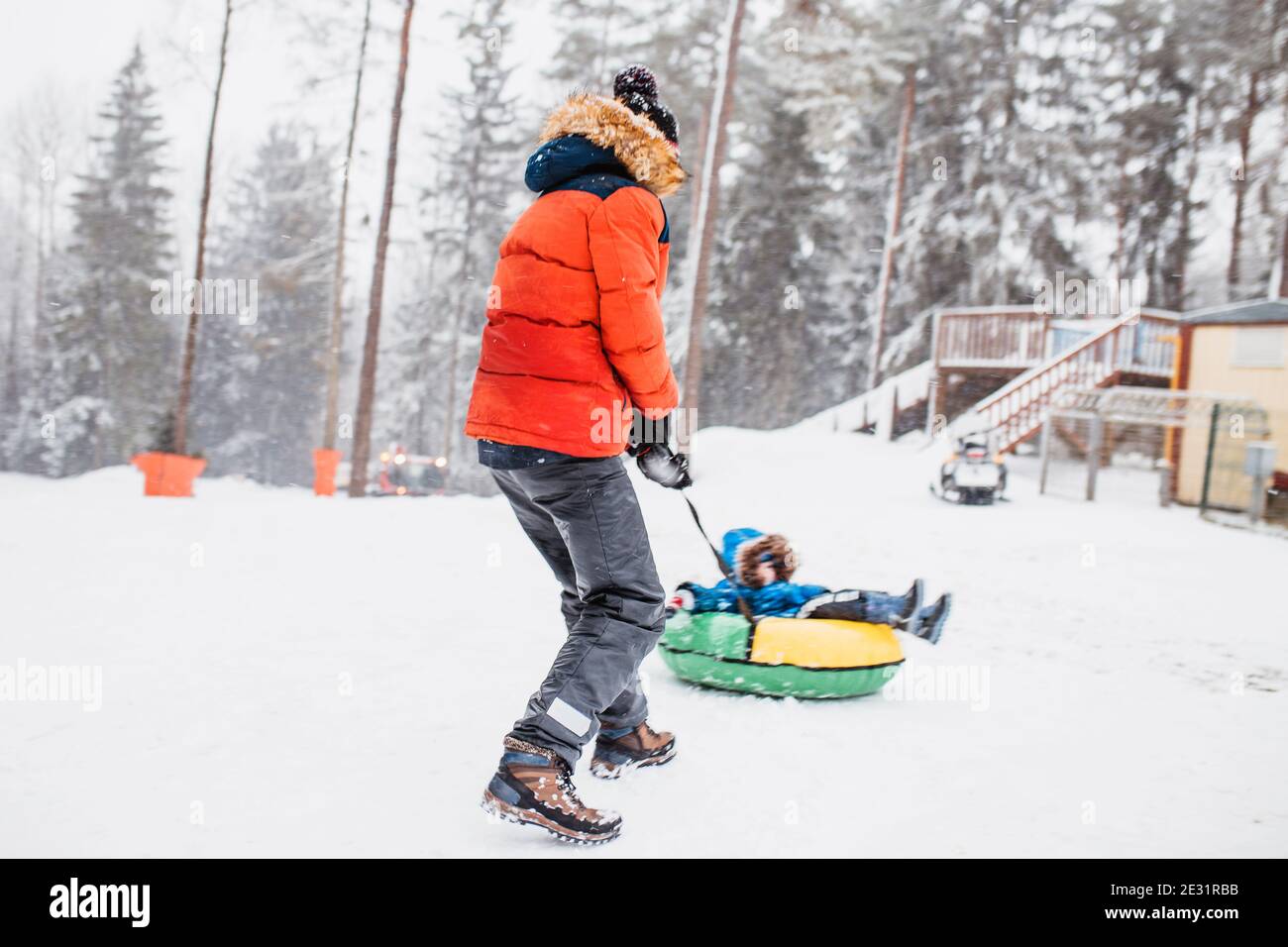 Jungs spielen auf einer Schneerutsche im Winter - Fahrt Ein aufblasbarer Schlauch - Winterurlaub Stockfoto