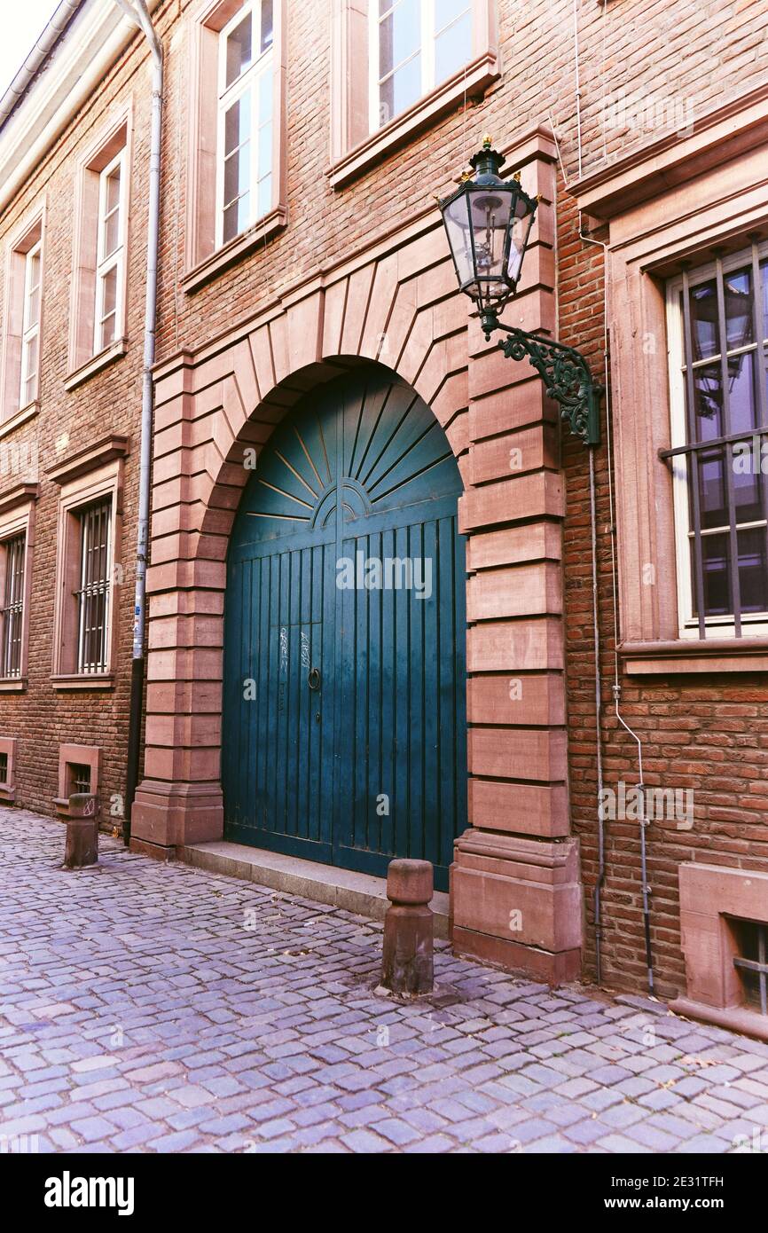 Typische alte Straße in der historischen Düsseldorfer Altstadt: Altes Backsteingebäude am Rhein mit blauer Tür, alte Gaslaterne und Pflastersteinpflaster. Stockfoto