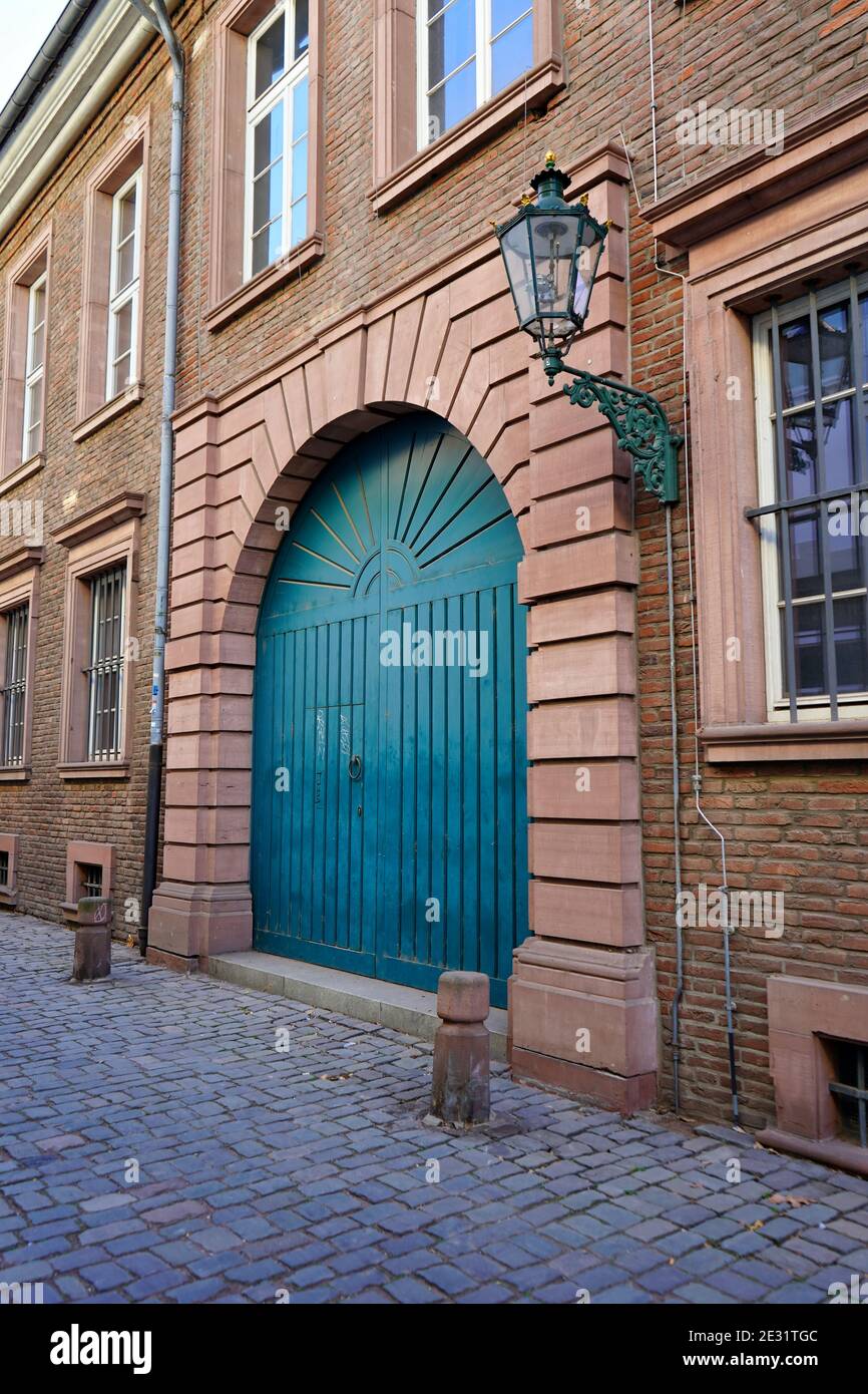 Typische alte Straße in der historischen Düsseldorfer Altstadt: Altes Backsteingebäude am Rhein mit blauer Tür, alte Gaslaterne und Pflastersteinpflaster. Stockfoto