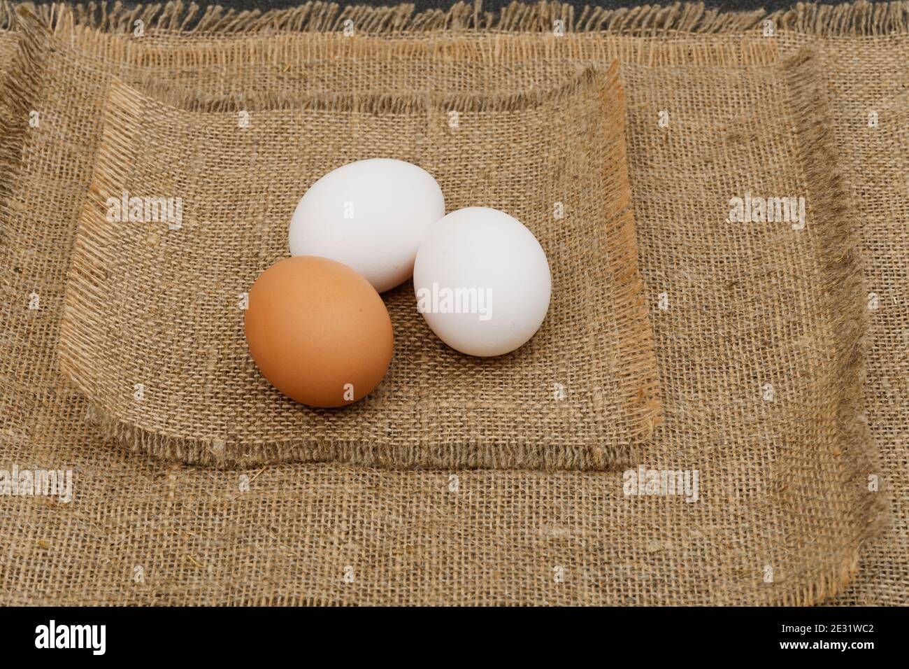 Drei Eier liegen auf dem rohen Sacktuch Stockfoto