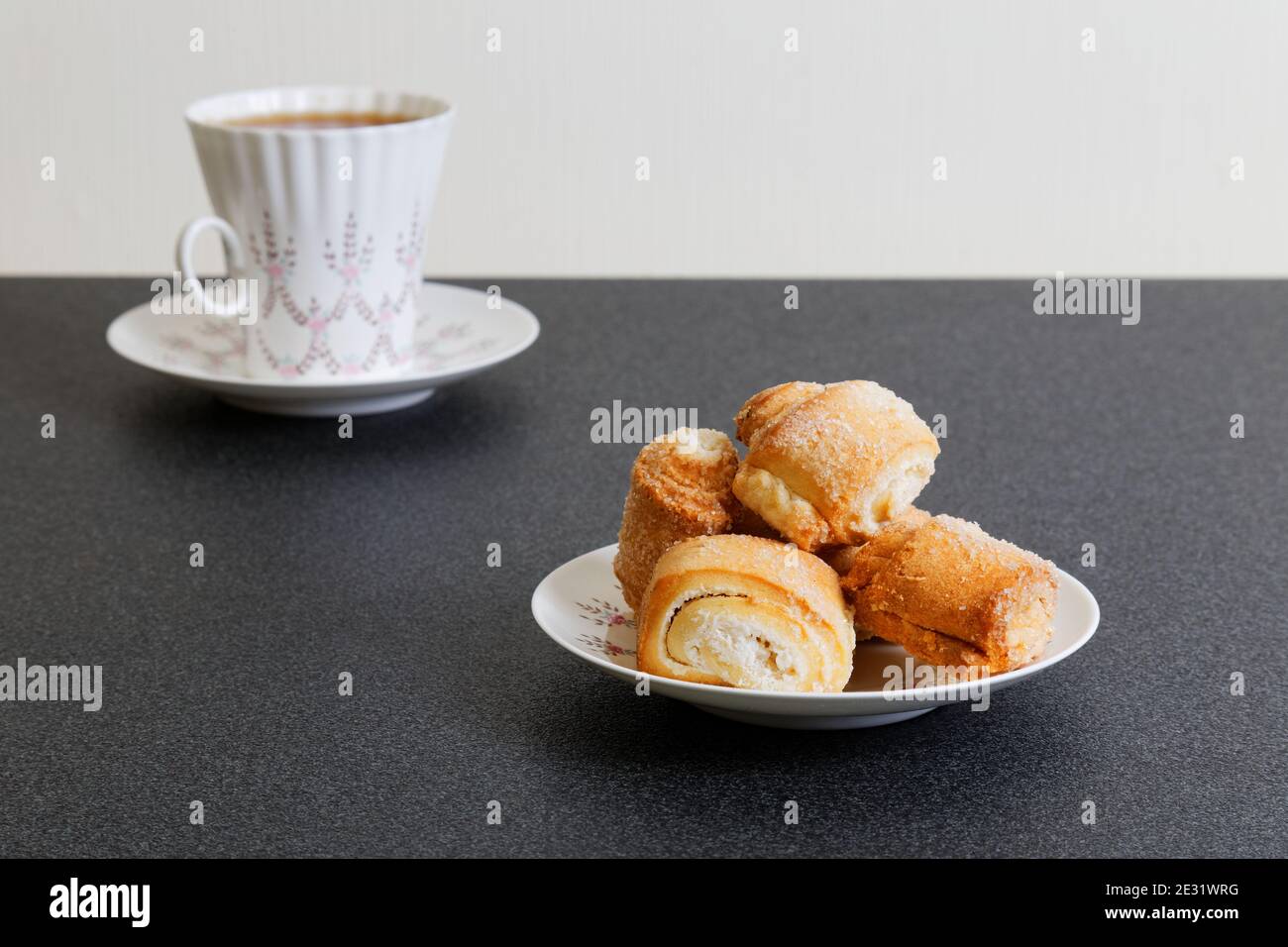Kekse und entkochte Tasse Tee auf dem dunklen Tisch Stockfoto