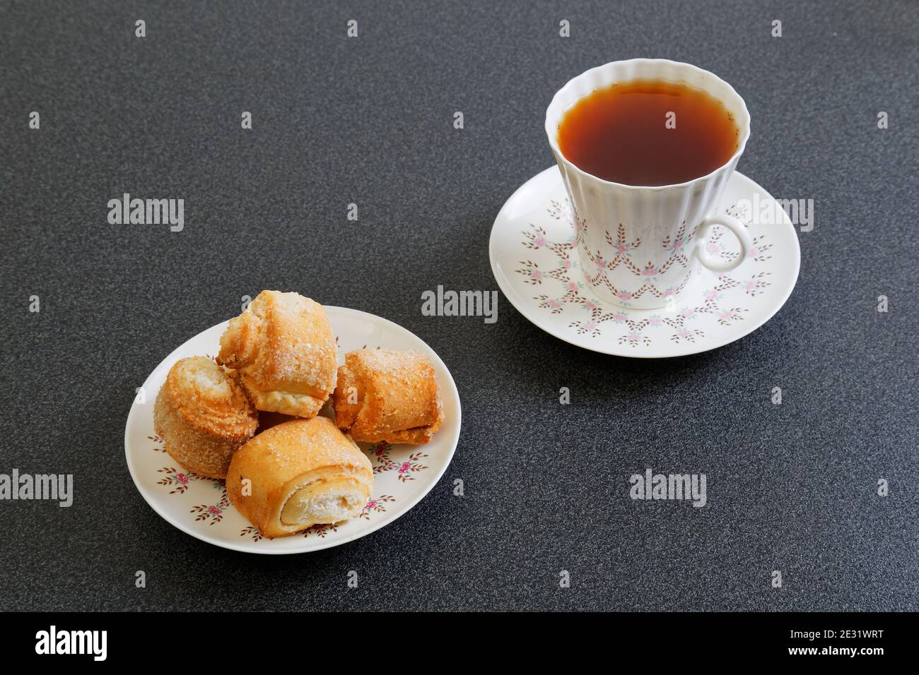 Kekse und eine Tasse Tee auf dem dunklen Tisch Stockfoto