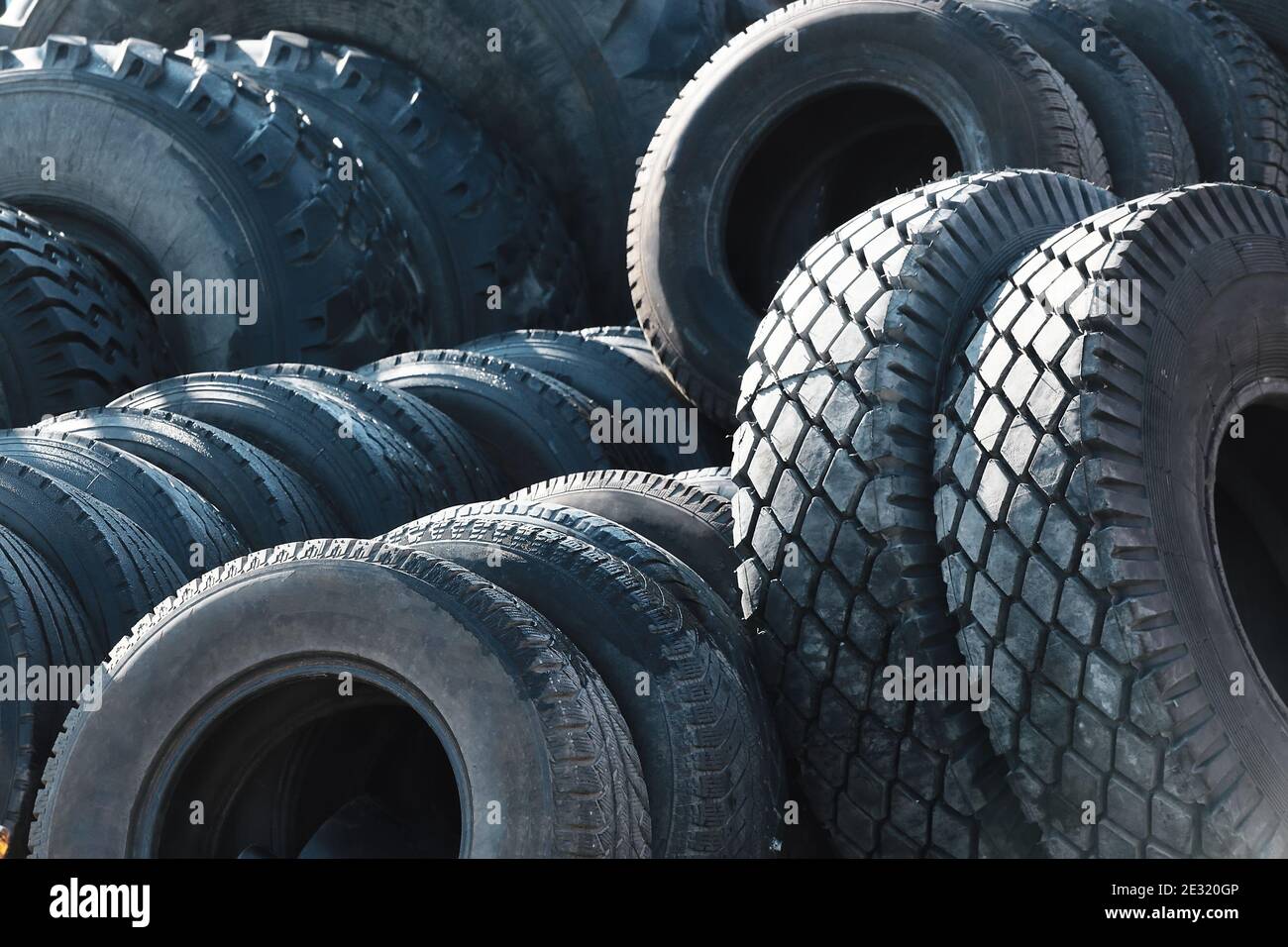 Recycling von Autoreifen für LKW. Das sind viele schwarze Glatzenreifen, die draußen in einem offenen Lager liegen. Stockfoto