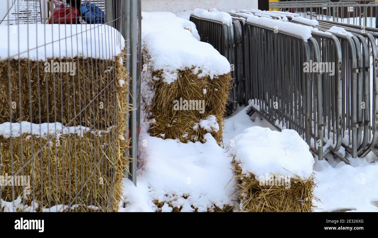 Im Winter wird auf der Messe im Schnee im Freien ein tragbarer Metall-Eventzaun an einem Ort gehalten. Graue Gitter zum Überladen des Bereichs und zum Organisieren des Stockfoto