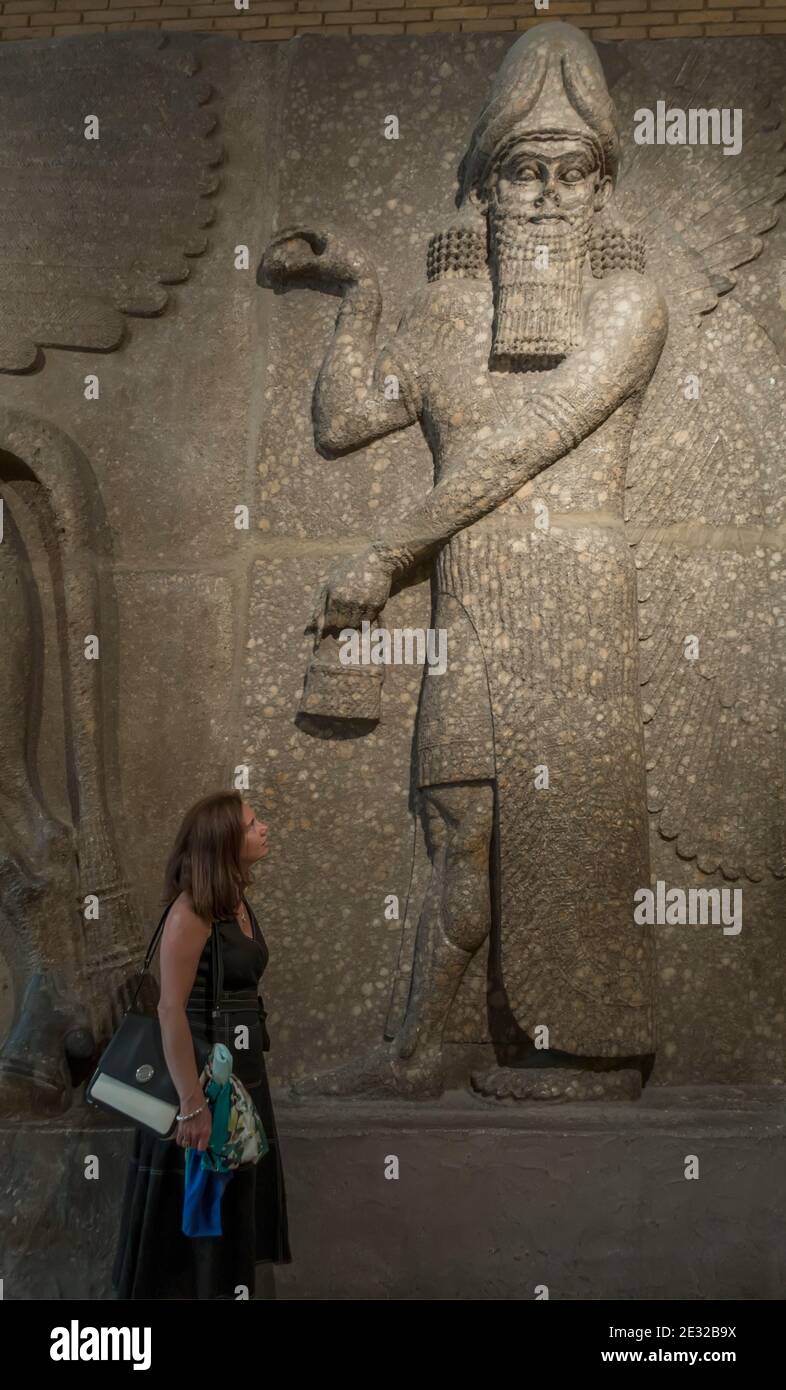 Frau betrachtet ein assyrisches Relief im British Museum, London, England, Großbritannien Stockfoto