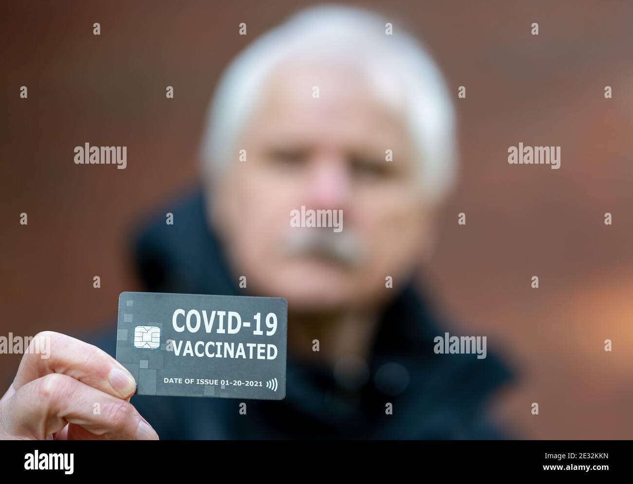 Älterer Mann mit einem Impfpass, der auf eine Impfung gegen covid-19 hinweist. Stockfoto