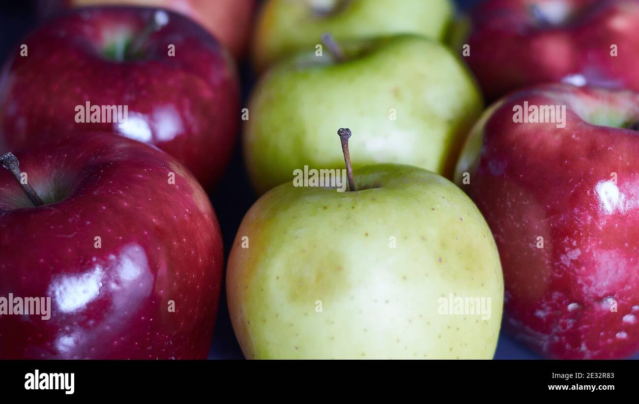 Mehrere leuchtend rote Äpfel und grüne Äpfel. Nahaufnahme von roten und grünen Äpfeln. Rote und grüne Äpfel in einer Reihe. Stockfoto