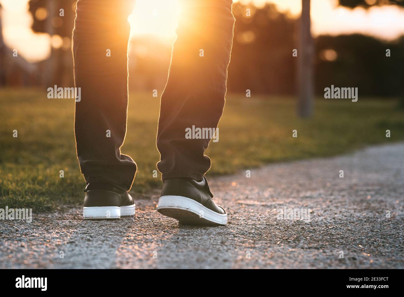 Mann, der bei Sonnenuntergang im Park spazieren geht. Der Mensch auf dem Weg zu einem neuen besseren Leben. Der Weg nach vorn. Neuanfang, neues Leben und Freiheitskonzept. Stockfoto