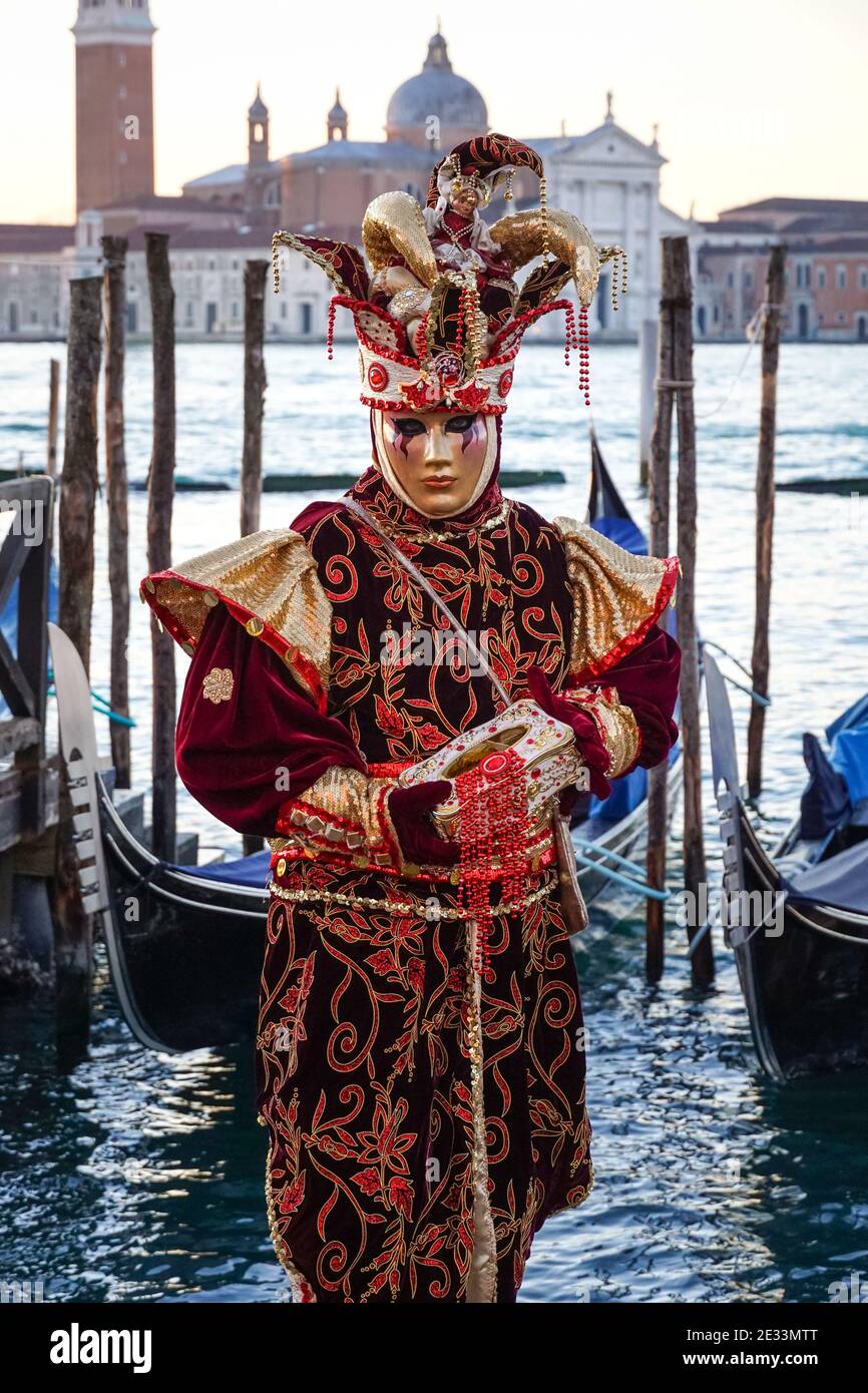 Menschen, die während des Karnevals in Venedig, Italien, in traditionell dekorierten Kostümen und bemalten Masken gekleidet waren Stockfoto