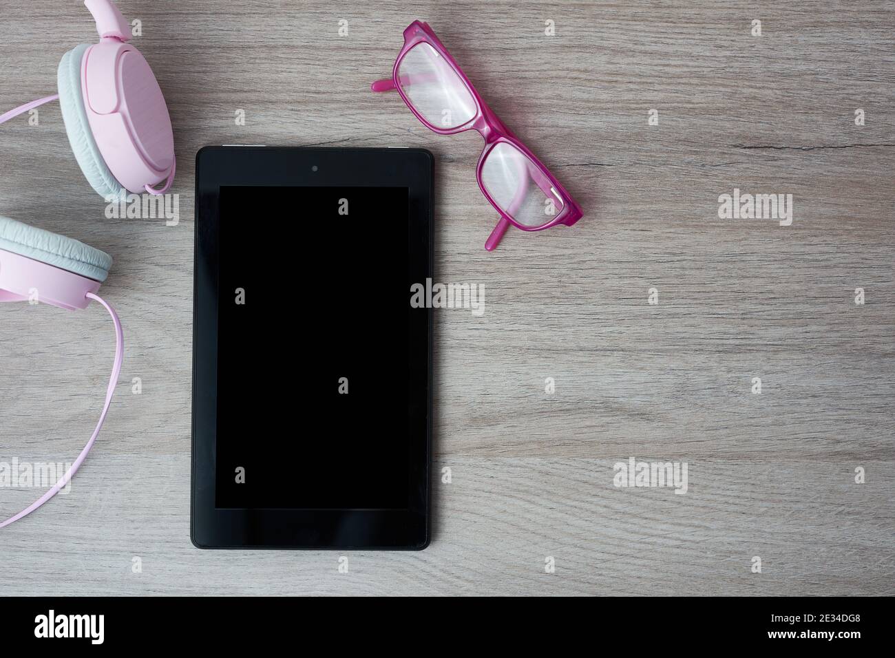 Stillleben mit Tablet, rosa Brille und Mädchen Kopfhörer, freier Platz für Text Stockfoto