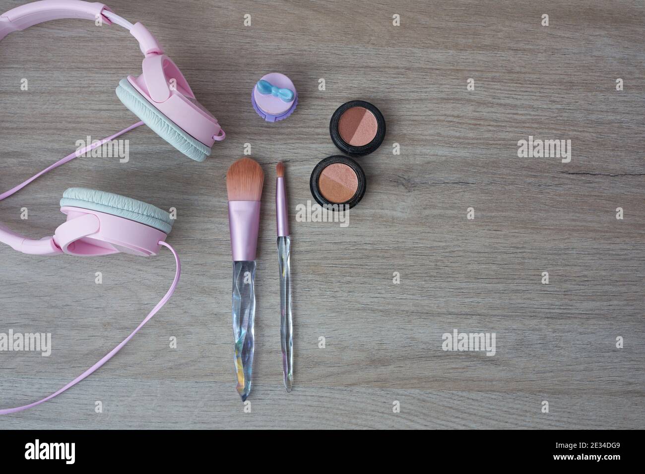 Pinke Kopfhörer, Pinsel und weibliches Make-up mit Platz für Text Stockfoto