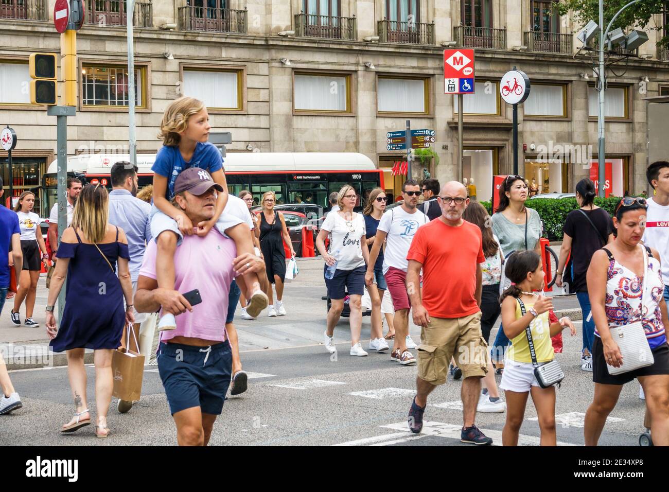 Catalonia Catalunya Passeig de Gracia Geschäftsviertel Kreuzung Straße überqueren Fußgänger Hispanic Mann Frau Junge Mädchen Vater Sohn trägt auf Schultern beschäftigt überfüllten Crosswalk Familien Stockfoto