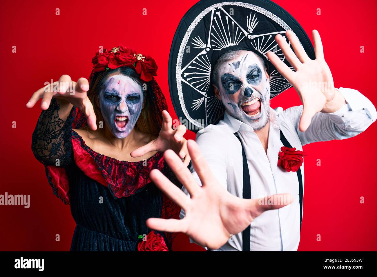 Schones Paar Tragt Tag Der Toten Kostum Gestikuliert Als Zombie Uber Isolierten Roten Hintergrund Stockfotografie Alamy