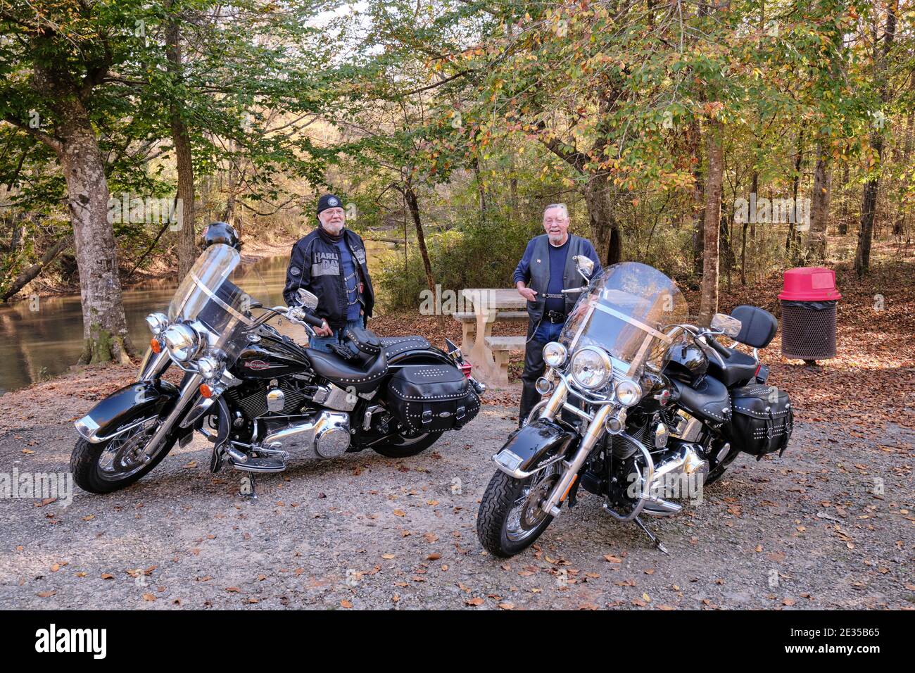 Zwei geparkte schwarze Harley Davidson Motorräder und ihre Fahrer tragen schwarzes Leder. Stockfoto