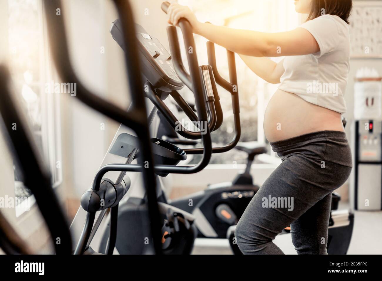 Aktive schwangere Frau Übung im Fitnesscenter im Yogaraum. Die junge Mutter mit Baby erwartet bei schwangeren Bauch. Mutterschaft pränatale Versorgung und Stockfoto