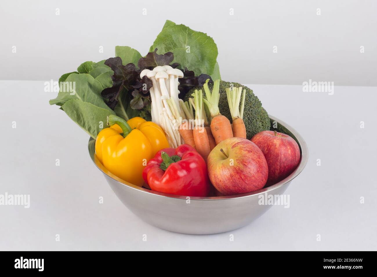 Gemüse und Obst in Edelstahlschüssel isoliert auf weiß Hintergrund Stockfoto
