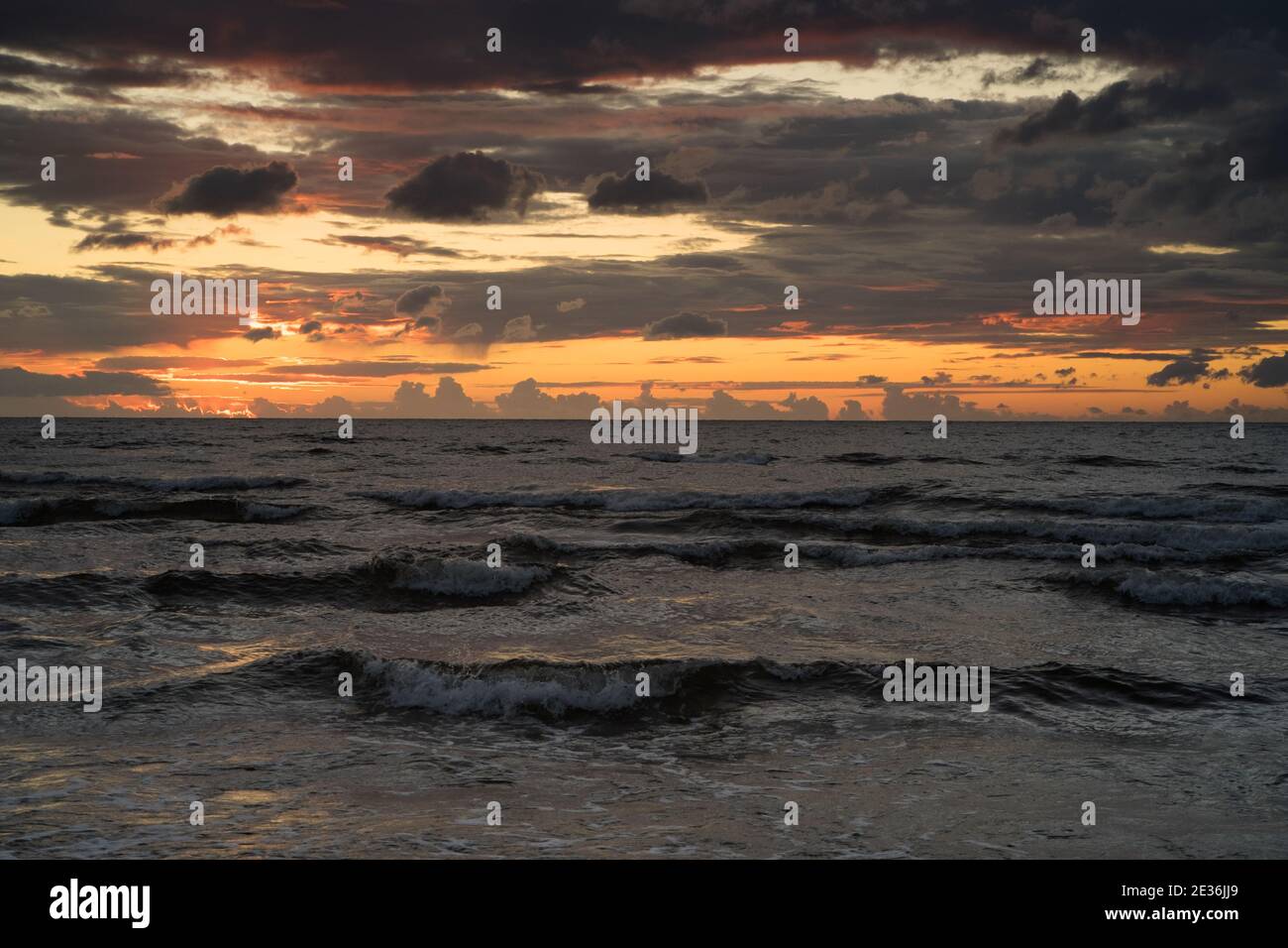 Dunkle Wellen und nach Sonnenuntergang Licht in den dunklen Wolken An der ostseeküste Stockfoto