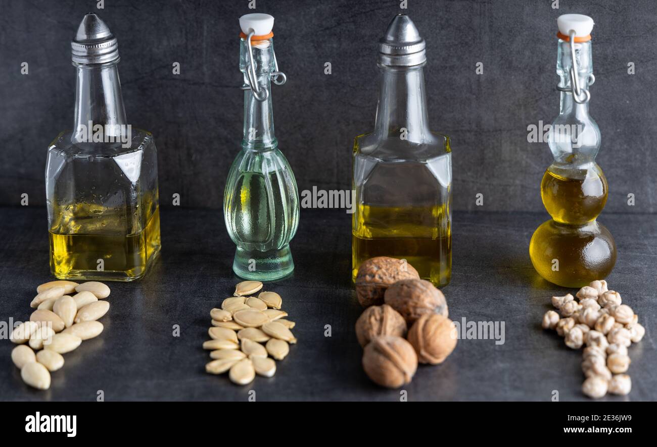 Variation von trendigen veganen Speiseölen in einem kleinen Glas auf einer Tischplatte. Stockfoto