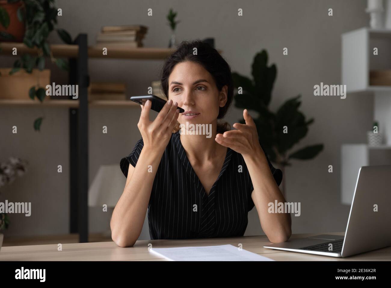 Kaukasische Frau sprechen auf dem Smartphone über Lautsprecher Stockfoto