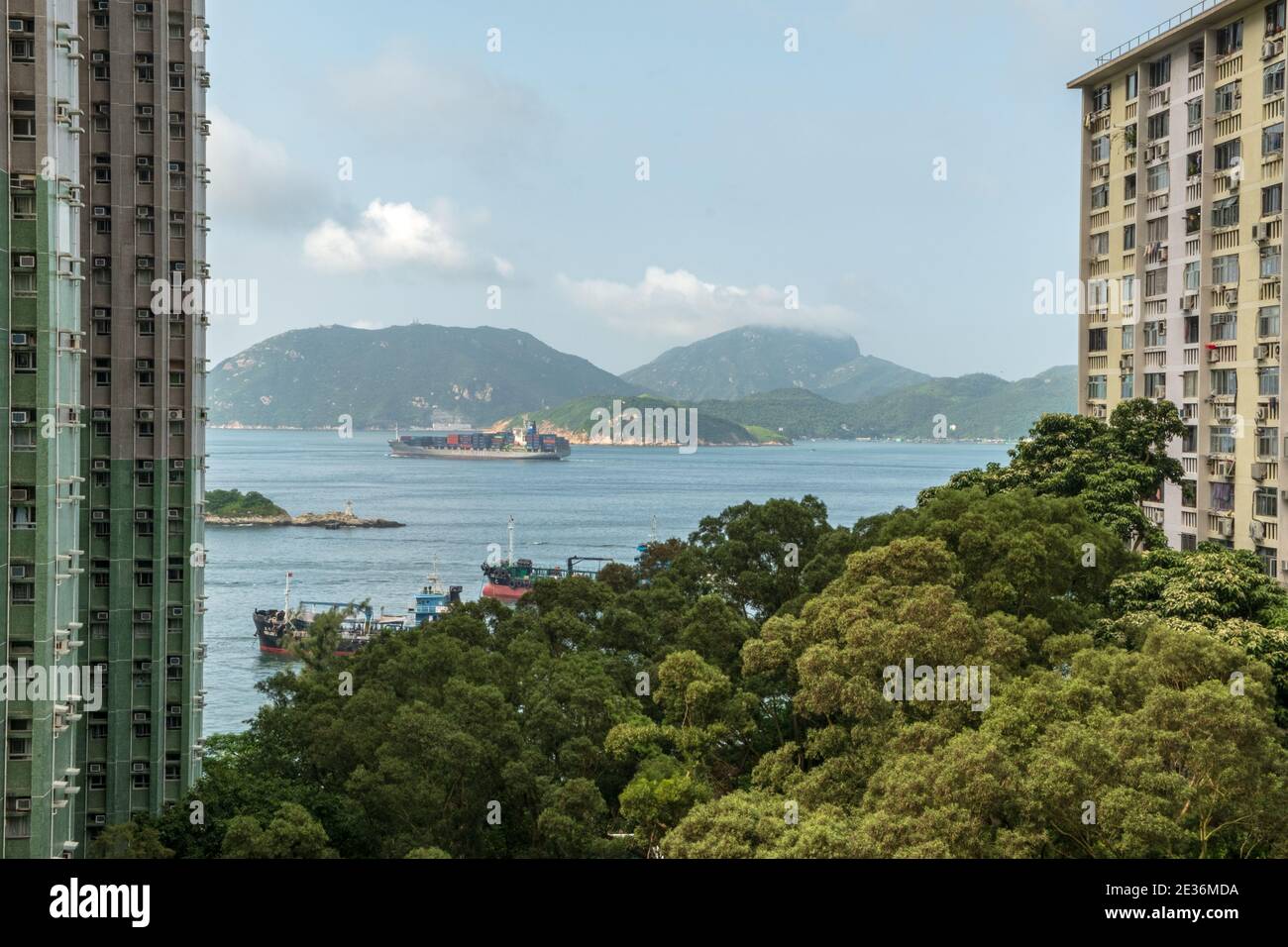 Lamma Island erstreckt sich über den Kanal vom Wah Fu Estate in Aberdeen, Hongkong, an einem sonnigen, heißen Tag, an dem das lebhafte Leben in öffentlichen Häusern zum Vorschein kommt. Stockfoto Lamma Island erstreckt sich über den Kanal vom Wah Fu Estate in Aberdeen, Hongkong, an einem sonnigen, heißen Tag, an dem das lebhafte Leben in öffentlichen Häusern zum Vorschein kommt. Stockfoto