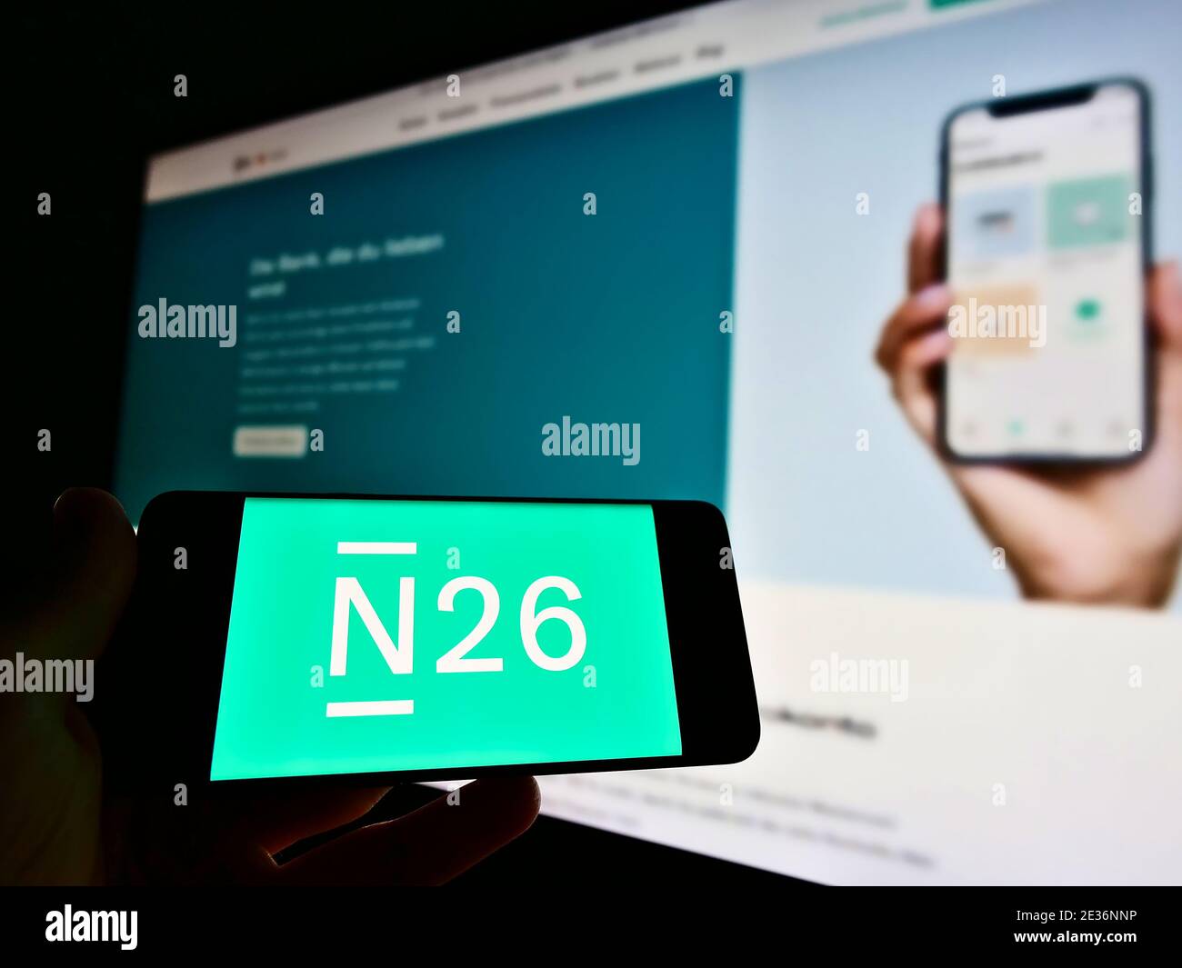 Person, die Smartphone mit Logo der deutschen Direktbank N26 mit Website im Hintergrund hält. Konzentrieren Sie sich auf den Bildschirm des Mobiltelefons. Nicht modifiziertes Foto. Stockfoto