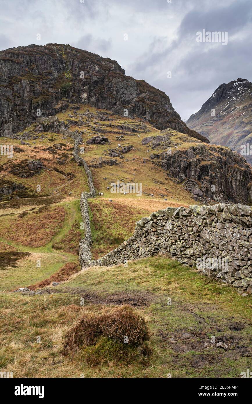 Atemberaubende Winterlandschaft Bild der Ansicht von Side Pike in Richtung Langdale Hechte mit niedrigen Wolken auf Bergspitzen und moody Mist Stockfoto