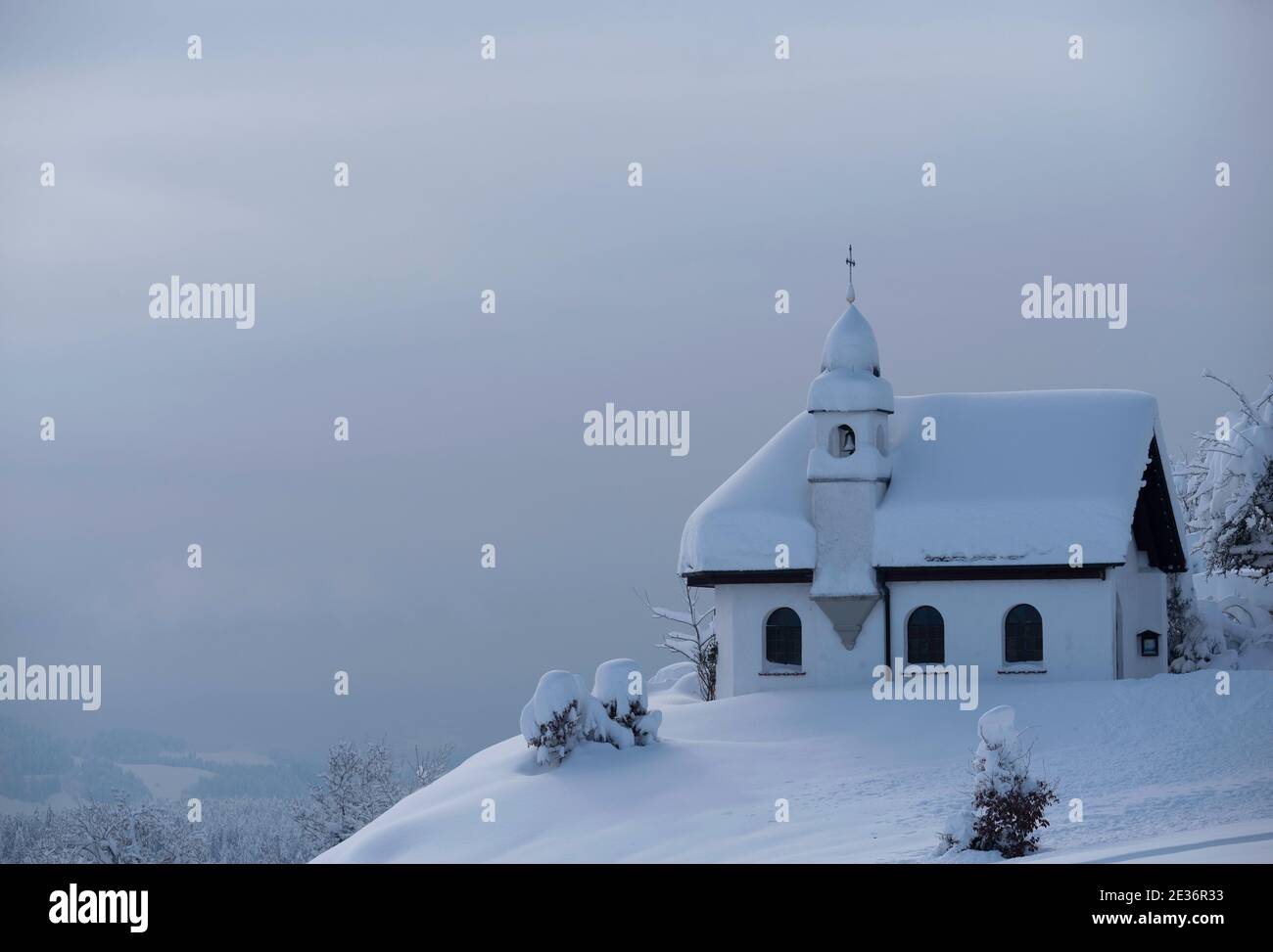 Deutschland, Scheidegg - 15. Januar 2019: Bayerische Kirche St. Hubertus Kapelle bedeckt mit Schnee an einem sonnigen Tag. Nahaufnahme mit einem bayrischen kleinen chu Stockfoto