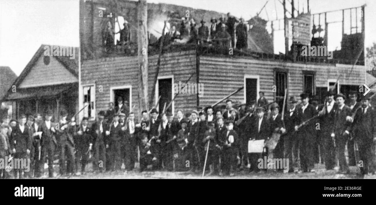 WILMINGTON MASSAKER North Carolina 10 November 1898. Mob posiert mit Waffen außerhalb der ausgebrannten Ruinen des Tagesrekord Stockfoto