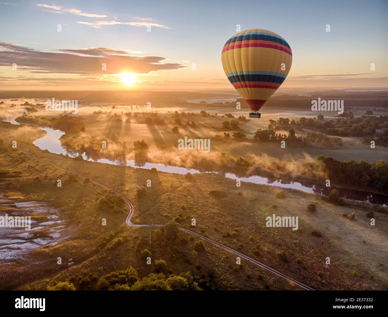 Heißluftballon über dem Fluss bei Sonnenuntergang. Reisen, Freiheit, Abenteuer, Erkundung, extremes Konzept. Stockfoto