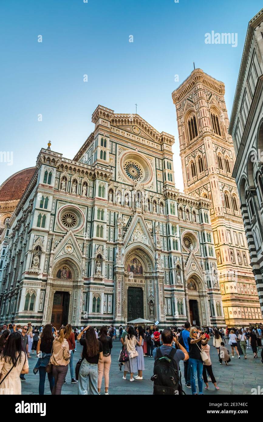 Besucher machen Fotos von der berühmten Kathedrale Santa Maria del Fiore in Florenz und dem Campanile von Giotto auf der Piazza del Duomo. Das Äußere des... Stockfoto