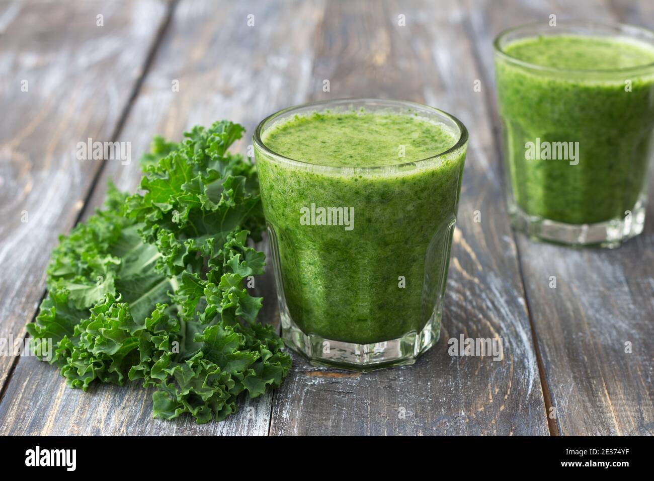 Grüne Smoothies mit Grünkohl, Banane und Zitrone. Auf einem Holztisch. Selektiver Fokus. Gesunde Ernährung Stockfoto