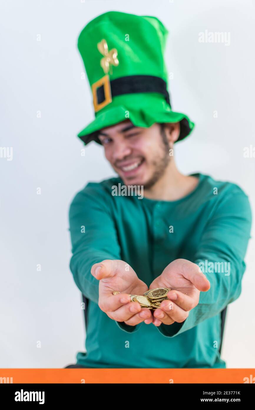 Ein schöner Mann in einem Kobold Hut trägt einen grünen Kostüm für eine  Party mit Goldmünzen am St. Patrick's Day Stockfotografie - Alamy