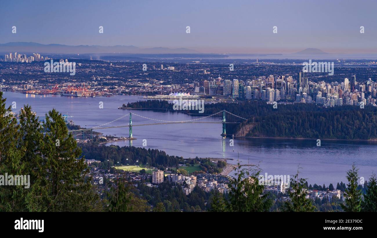Panoramablick auf die Stadtlandschaft von Vancouver, einschließlich der architektonischen Wahrzeichen Lions Gate Bridge und der Gebäude in der Innenstadt in der Abenddämmerung, British Columbia, Kanada. Stockfoto
