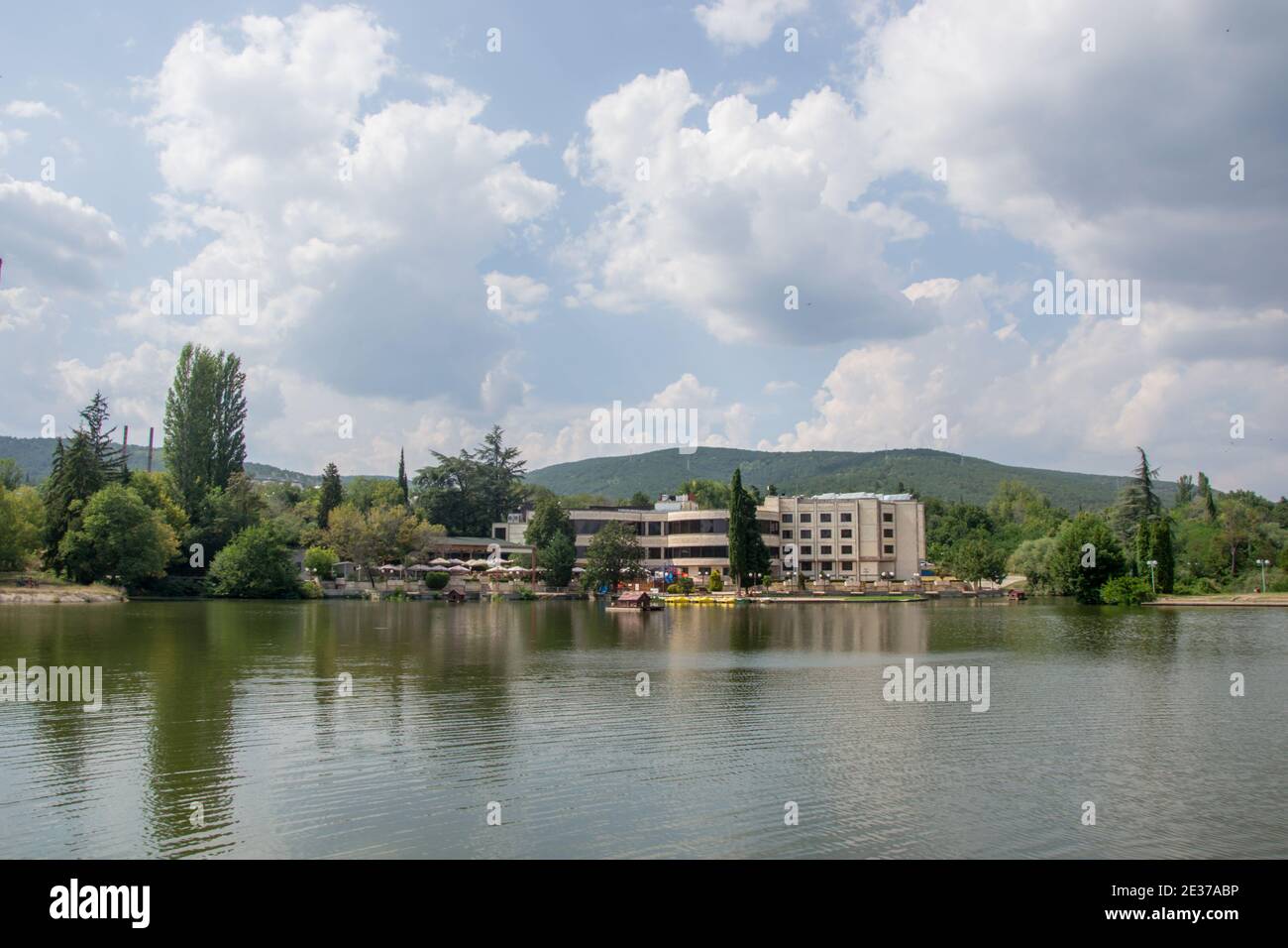 Schöne friedliche Natur, Bäume und Pflanzen auf einem See, Gebäude unter den Bäumen, Sommersaison, Reflexion im Wasser, Zagorka See, Stara Zag Stockfoto