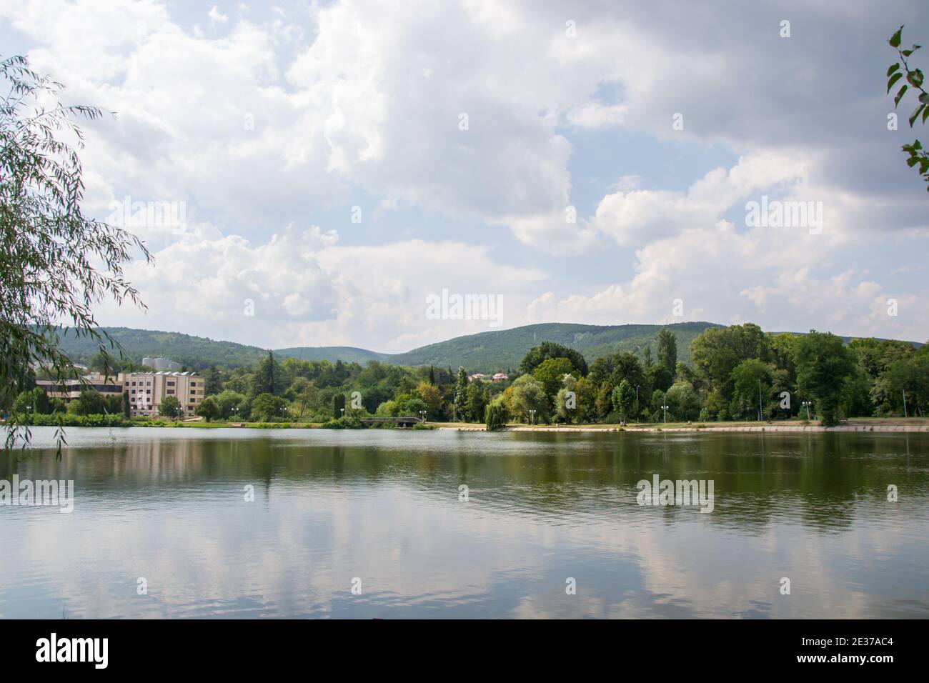 Schöne friedliche Natur, Bäume und Pflanzen auf einem See, Gebäude unter den Bäumen, Sommersaison, Reflexion im Wasser, Zagorka See, Stara Zag Stockfoto