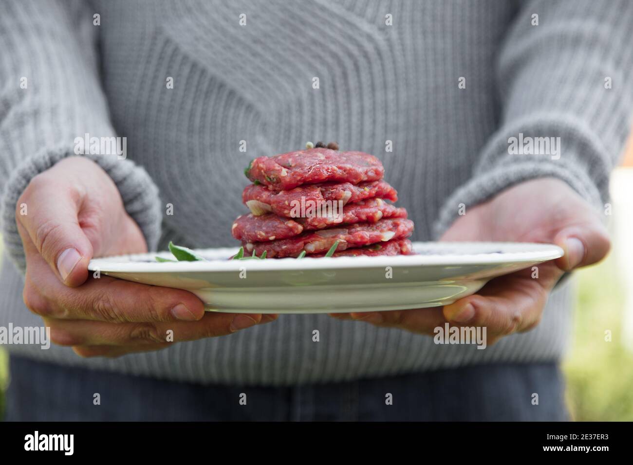 Mann hält Burger für BBQ. Barbecue-Burger Stockfoto